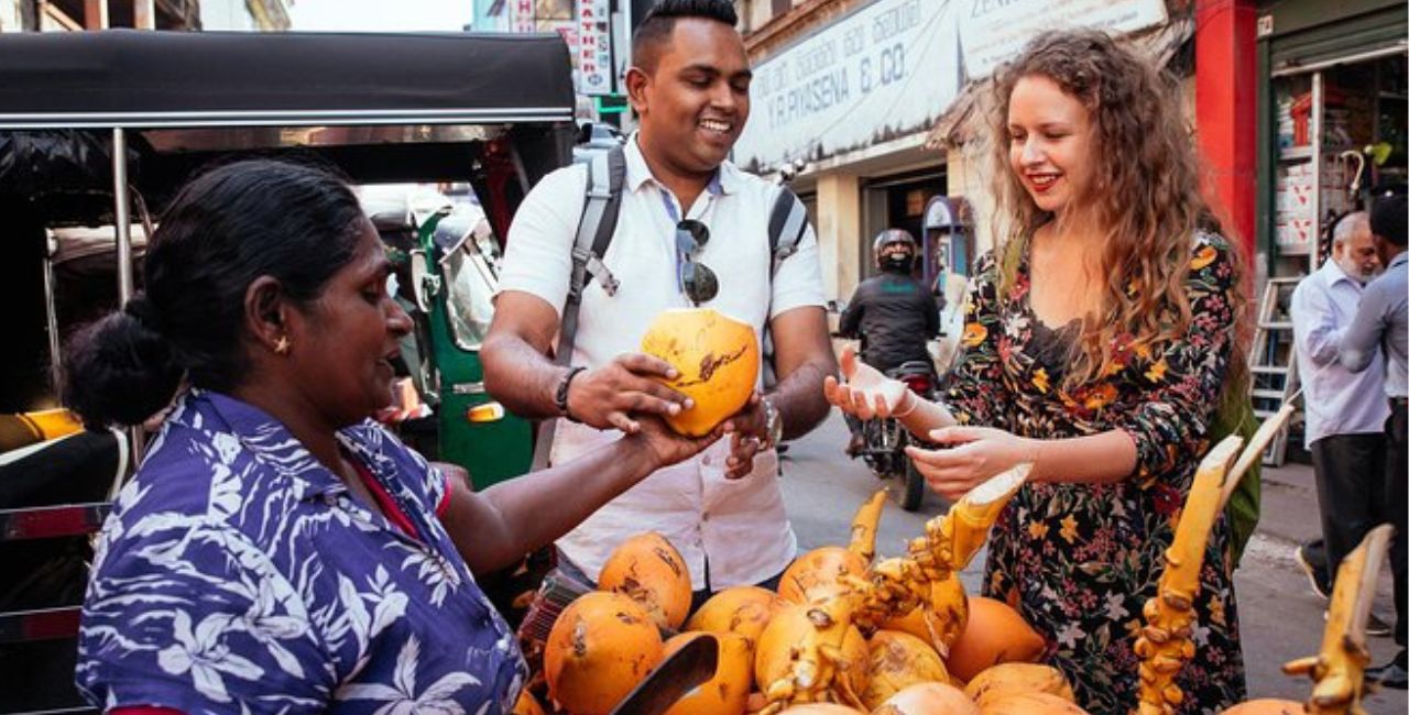 Two travellers are about to enjoy a King Coconut during a Colombo City Tour