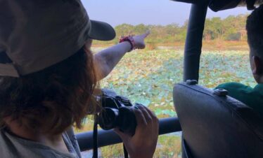 A Wilpattu safari guest is pointing at a bird