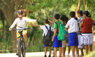 A cycle rider with children of a Sri Lankan Village