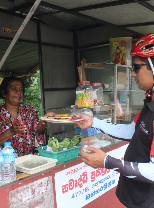cycle rider buying foods from a lady